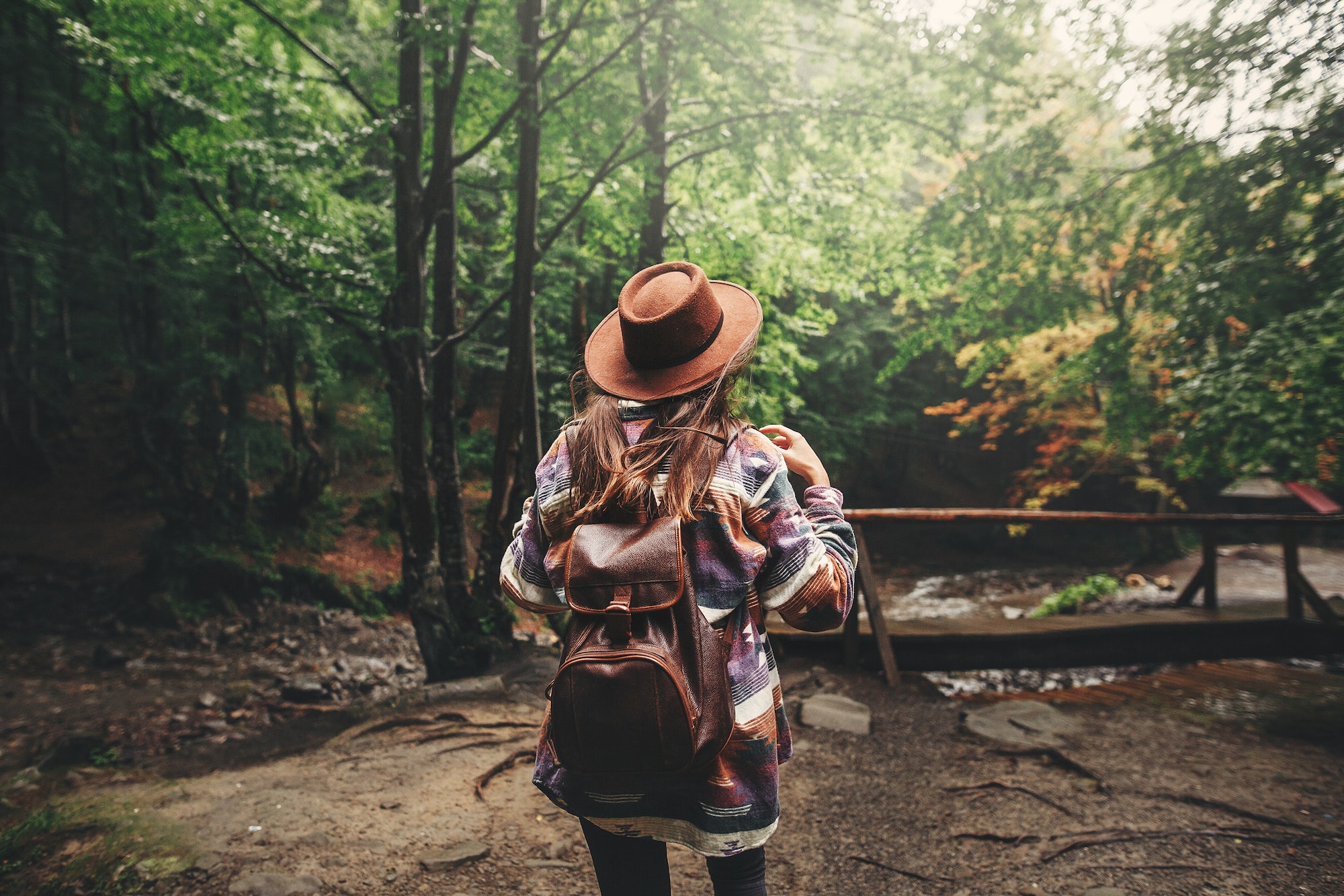 Stylish hipster girl in hat traveling in mountains